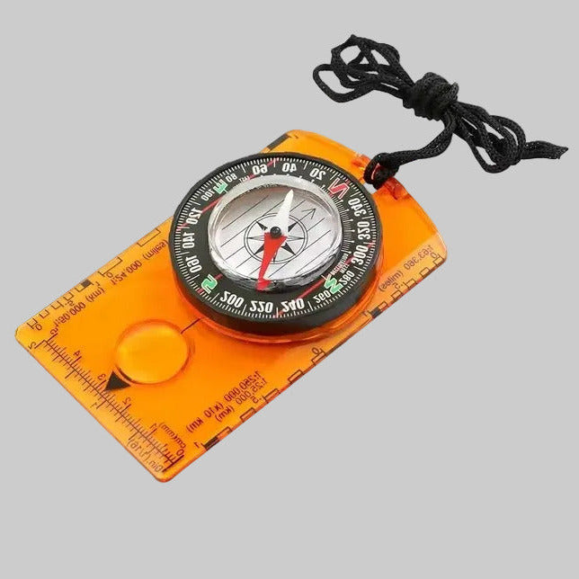 Compass with orange casing and black cord on a gray background