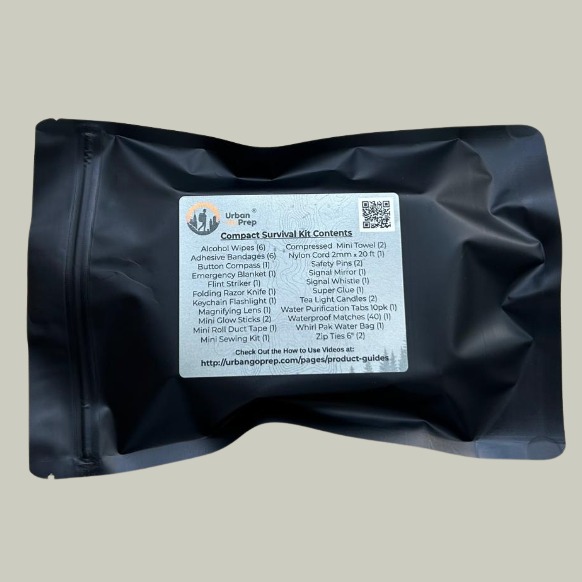 Black compact survival kit with a label on a gray background