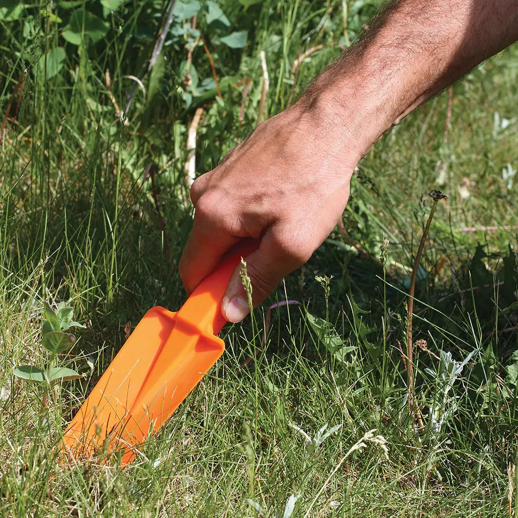Orange Camp Trowel in Use on grassy area